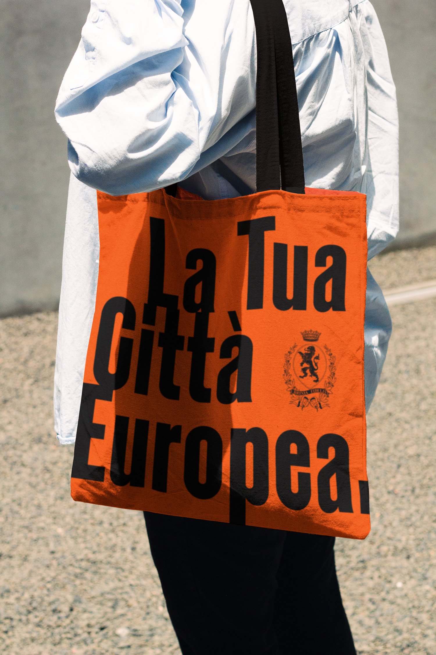 A woman carrying an orange bag with a black handle.
